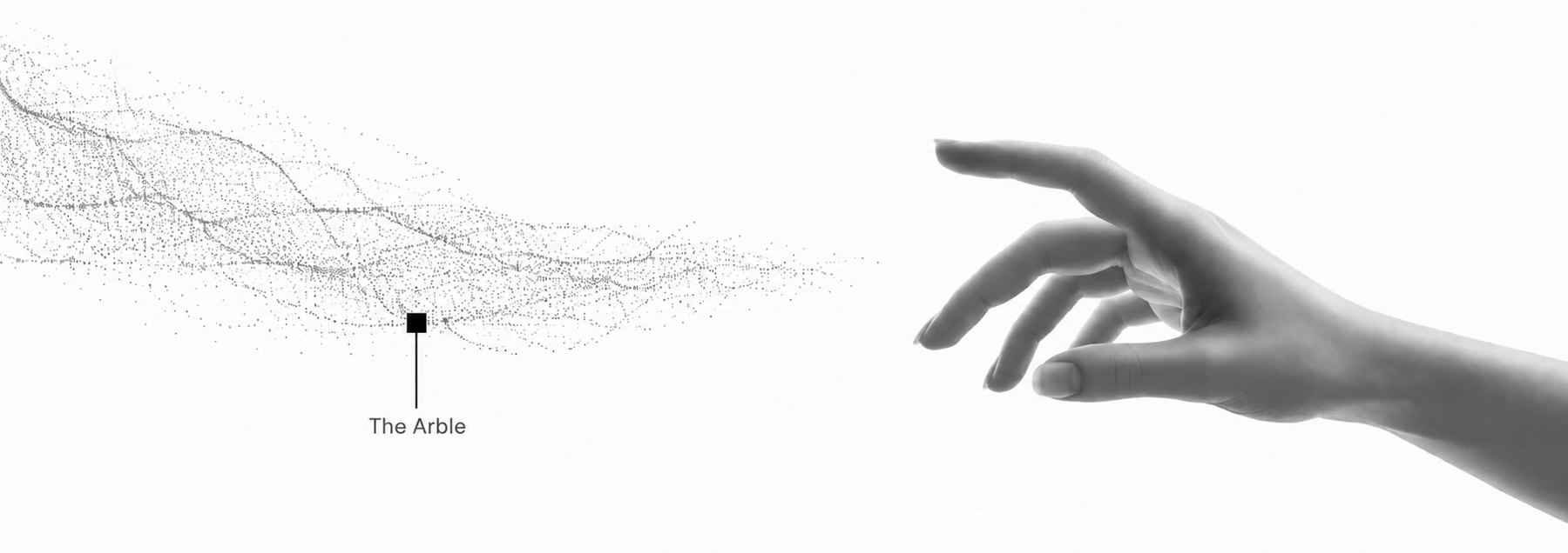 A drift of fine grey particles resolving out of the left edge and reaching toward an outstretched human hand on the right; a small square marker in the particle field is labelled 'The Arble'.